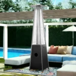 Goldoma patio heater lit with blue flames, standing on a stone patio near outdoor furniture.