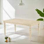 Urban style wired white dining table with turned legs and wood grain finish in a modern home setting