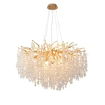 Gold crystal chandelier hanging in modern dining room with golden light reflections