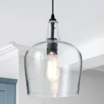 Seeded glass dome pendant light in matte black, hanging above a kitchen island with warm ambient glow.