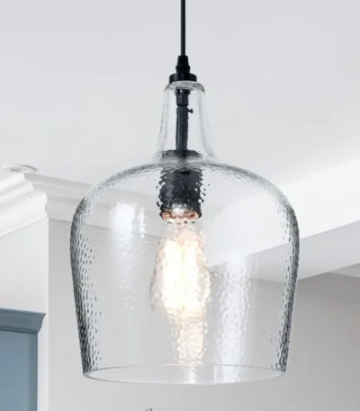 Seeded glass dome pendant light in matte black, hanging above a kitchen island with warm ambient glow.