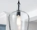 Seeded glass dome pendant light in matte black, hanging above a kitchen island with warm ambient glow.