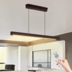 Goldoma 39.4 inch LED pendant light in black metal, hanging over a kitchen island with marble countertop.