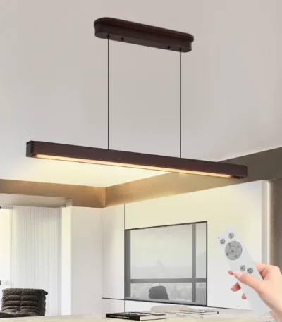 Goldoma 39.4 inch LED pendant light in black metal, hanging over a kitchen island with marble countertop.