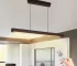 Goldoma 39.4 inch LED pendant light in black metal, hanging over a kitchen island with marble countertop.