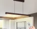 Goldoma 39.4 inch LED pendant light in black metal, hanging over a kitchen island with marble countertop.