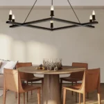 The chandelier illuminated above a dining table set with plates and glasses, casting warm light in a farmhouse-style