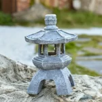 Solar pagoda lantern garden statue with gray stone finish and warm LED glow