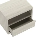 Whitewashed oak nightstand with open shelf and drawer in a modern bedroom setting