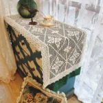 Elegant lace edge table runner on wooden dining table with centerpiece