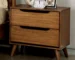 Mid century nightstand in solid oak with two drawers, placed beside a bed