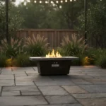 Modern metal propane fire pit on patio with glowing flames