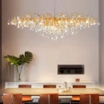 Modern crystal chandelier hanging in a dining room with gold finish and tree branch design