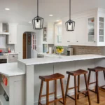 Black iron cage pendant light with visible bulb inside, suspended by a black cord.