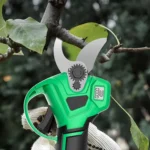 Goldoma cordless pruning shears cutting a thick branch in a garden