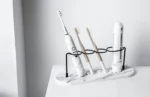 Toothbrush holder in matte black with a bamboo stand in an eco-friendly bathroom.