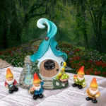 Front view of white gnome statue with solar light, nestled among green shrubs and colorful blooms.