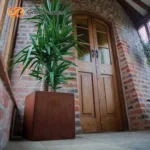 The outdoor flower pot from above, revealing the spacious opening and rustic metal finish with subtle reflections.