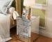 Modern crystal nightstand with drawers featuring mirrored finish and diamond details in a glamorous bedroom setting