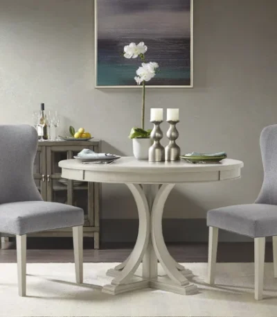 Modern round dining table in antique cream finish with solid wood legs, perfect for a stylish dining room.