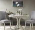 Modern round dining table in antique cream with wooden legs in a bright dining room