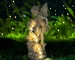 Solar fairy statue glowing in a garden at dusk