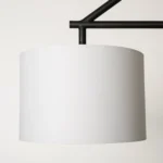 HMS modern hanging light in a hotel lobby setting, three warm white bulbs illuminating the reception area.