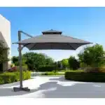 Dark gray rectangular tilt cantilever patio umbrella with stand in outdoor setting