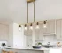 Modern gold chandelier with five clear glass shades and golden metal frame hanging from ceiling