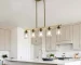 Modern gold chandelier with five clear glass shades and golden metal frame hanging from ceiling