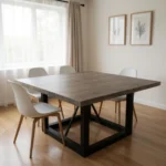 Goldoma 60-inch solid wood square dining table with dark brown distressed top and black iron legs in a rustic dining room