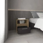 Modern rolling nightstand with one drawer and shelf in natural oak and black finish, placed beside a bed