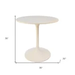 White rounded marble pedestal base dining table with iron base in a modern dining room
