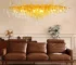 Modern crystal chandelier with brass and black finish illuminating a living room