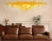 Modern crystal chandelier with brass and black finish illuminating a living room