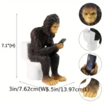 Side view of the resin sasquatch garden statue, highlighting its hairy arms and toilet seat, set against a patio with