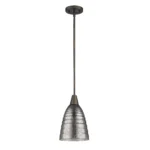 Bronze pendant light with pebbled glass shade illuminating a cozy corner of a hotel lobby, paired with neutral decor.