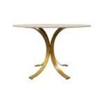 Elegant round marble dining table with ivory marble top and brass pedestal base in a modern dining room