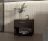 Minimalist bedroom nightstand in stained walnut with drawer and shelf beside a bed