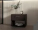 Minimalist bedroom nightstand in stained walnut with drawer and shelf beside a bed