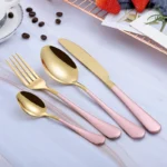 Elegant gold flatware set with fork, knife, and spoon on a white tablecloth