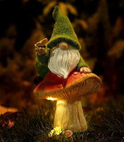 Solar gnome statue glowing in a garden at dusk