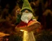 Solar gnome statue glowing in a garden at dusk