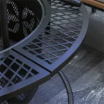 Black outdoor fire pit with glowing flames in a backyard setting