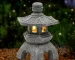 Solar pagoda lantern garden statue with gray stone finish and warm LED glow
