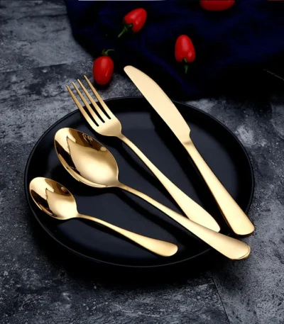 Elegant gold flatware set with fork, knife, and spoon on a white tablecloth