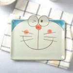 Japanese ceramic dinnerware set with hand-drawn cat design on blue rectangular plate and bowl