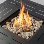 Modern outdoor gas fire pit column with blue flames on a stone patio