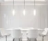 Modern Nordic glass pendant light in black metal, hanging over a wooden dining table.