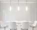 Modern Nordic glass pendant light in black metal, hanging over a wooden dining table.